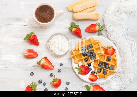 Hausgemachte belgische Waffeln mit Erdbeeren und Heidelbeeren. Köstliches Frühstück mit Beeren. Stockfoto