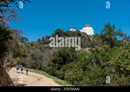 Ein Vater und zwei Kinder wandern an einem wunderschönen Tag in diesem offenen und touristischen Ziel von Los Angeles den Hügel zum Griffith Observatory auf dem West Trail hinauf. Stockfoto