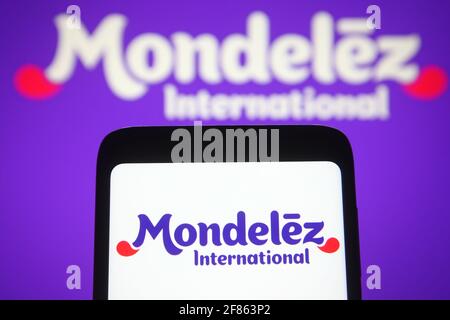 In dieser Abbildung ist das Mondelez International-Logo auf einem Smartphone und einem pc-Bildschirm zu sehen. Stockfoto