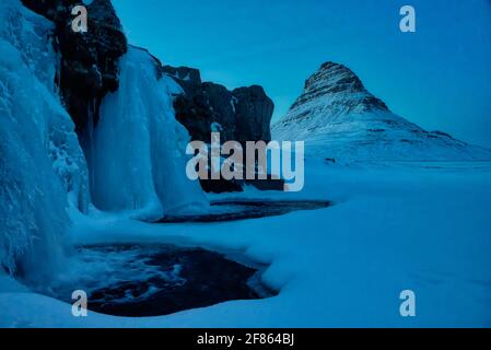 Kirkjufell ist ein 463 Meter hoher Berg, der das Leben einiger Bergsteiger gefordert hat. Aus dem rechten Winkel gleicht der Berg einem Kirchturm Stockfoto