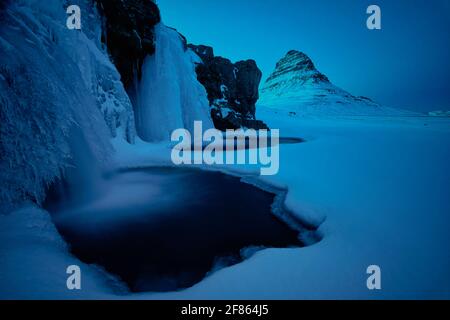 Kirkjufell ist ein 463 Meter hoher Berg, der das Leben einiger Bergsteiger gefordert hat. Aus dem rechten Winkel gleicht der Berg einem Kirchturm Stockfoto