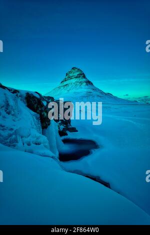 Kirkjufell ist ein 463 Meter hoher Berg, der das Leben einiger Bergsteiger gefordert hat. Aus dem rechten Winkel gleicht der Berg einem Kirchturm Stockfoto