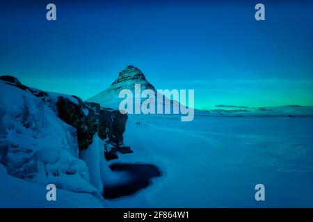 Kirkjufell ist ein 463 Meter hoher Berg, der das Leben einiger Bergsteiger gefordert hat. Aus dem rechten Winkel gleicht der Berg einem Kirchturm Stockfoto