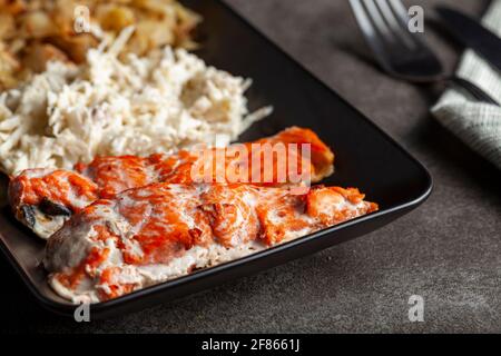 Eine Portion im Ofen gekochter marinierter Lachsfilets mit Kohl und Sellerie-Salaten, um den Ballaststoff- und Vitamingehalt zu erhöhen. Eine gesunde, ausgewogene Ernährung concep Stockfoto