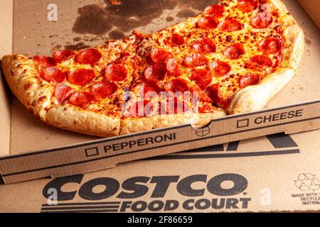 Clarksburg, MD, USA 04-07-2021: Nahaufnahme eines isolierten Bildes von köstlicher, frisch zubereitter Pepperoni-Pizza in Scheiben geschnitten und in Karton gelegt. Es ist ein beliebtes f Stockfoto