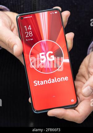 09. April 2021, Hessen, Frankfurt/Main: "5G Standalone" steht auf dem Display eines Mobiltelefons des chinesischen Herstellers "Oppo", das ein Vodafone-Mitarbeiter am ersten "Standalone"-Standort in Frankfurt zeigt. Die Technologie an diesem Standort basiert nicht mehr auf dem Vorgängerstandard LTE, sondern komplett auf 5G. Der genaue Standort der Anlage wird aus Sicherheitsgründen vom Unternehmen nicht veröffentlicht. (Zur dpa 'Vodafone startet Live-Betrieb für die nächste Entwicklungsstufe von 5G' ab 12.04.2021) Foto: Boris Roessler/dpa Stockfoto