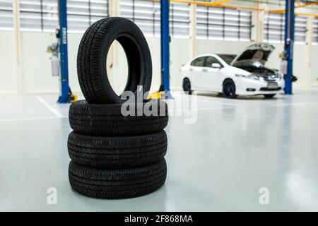 Neue Reifen, die die Reifen im Reparaturzentrum wechseln, neue Autoreifen und verschwommener Hintergrund Stockfoto