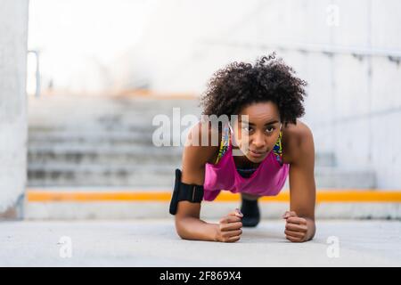 Afro-Athlet Frau tun Liegestütze im Freien. Stockfoto