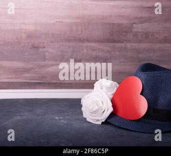 Herren Accessoire Geschenk zum Vatertag oder Jubiläum auf Holztisch Hintergrund, weiße Rosen, Hut und rotes Herz. Text für Leerzeichen kopieren. Stockfoto