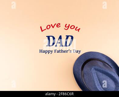 Das Konzept der Happy Father's Day Inschrift mit blauem Hut auf gelbem Hintergrund. Stockfoto