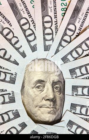 Viele gefaltete 100 USD-Scheine layed Wie Vintage-Sonnengesicht strahlt um Benjamin Franklin Porträt aus 100 Dollar US-amerikanische Rechnung Stockfoto
