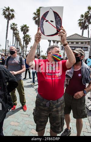 Huntington Beach, Usa. April 2021. Ein Gegenprotegter der Weißen Leben hält ein Plakat, das den Ku Klux Klan während der Demonstration herabwürdigt. Als sich auf verschiedenen Social Media- und Messaging-Plattformen die Aussage verbreitete, dass es um 13 Uhr einen „White Lives Matter“-Protest am Huntington Beach Pier geben sollte, kam eine große Gruppe von Gegendemonstlern am Pier an, um den „White Lives Matter“-Protest zu stoppen. Der Tag führte zu Zusammenstößen zwischen Gegenprotestierenden und Demonstranten, die verbal und physisch auf White-Lives-Matter-Ebene waren. Kredit: SOPA Images Limited/Alamy Live Nachrichten Stockfoto