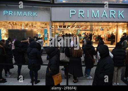 Am frühen Morgen stehen die Käufer vor Primark, Birmingham, Schlange und warten auf die Wiedereröffnung des Geschäfts, während England mit der weiteren Lockerung der Sperrbeschränkungen einen weiteren Schritt zurück in Richtung Normalität unternimmt. Bilddatum: Montag, 12. April 2021. Stockfoto