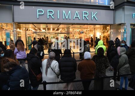 Am frühen Morgen stehen die Käufer vor Primark, Birmingham, Schlange und warten auf die Wiedereröffnung des Geschäfts, während England mit der weiteren Lockerung der Sperrbeschränkungen einen weiteren Schritt zurück in Richtung Normalität unternimmt. Bilddatum: Montag, 12. April 2021. Stockfoto