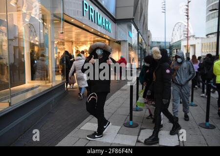 Am frühen Morgen stehen die Käufer vor Primark, Birmingham, Schlange und warten auf die Wiedereröffnung des Geschäfts, während England mit der weiteren Lockerung der Sperrbeschränkungen einen weiteren Schritt zurück in Richtung Normalität unternimmt. Bilddatum: Montag, 12. April 2021. Stockfoto