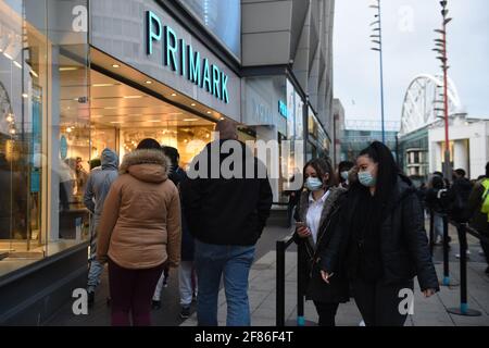 Am frühen Morgen stehen die Käufer vor Primark, Birmingham, Schlange und warten auf die Wiedereröffnung des Geschäfts, während England mit der weiteren Lockerung der Sperrbeschränkungen einen weiteren Schritt zurück in Richtung Normalität unternimmt. Bilddatum: Montag, 12. April 2021. Stockfoto