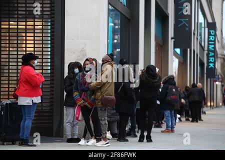 Am frühen Morgen stehen die Käufer vor dem Primark-Store in der Oxford Street in London Schlange und warten darauf, dass das Geschäft für die Kunden wieder geöffnet wird, da England einen weiteren Schritt zurück in Richtung Normalität unternimmt und die Sperrbeschränkungen weiter gelockert werden. Bilddatum: Montag, 12. April 2021. Stockfoto