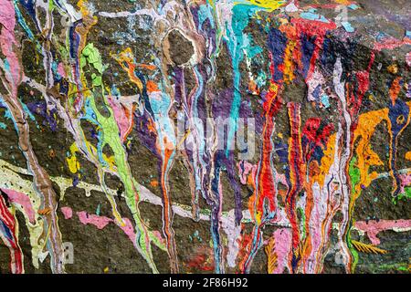 Viele Farben der Farbe sind auf einem Felsen verschüttet Stockfoto