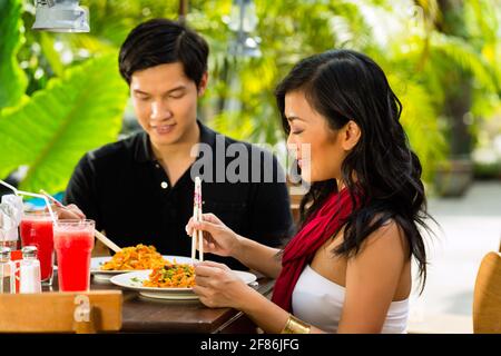 Asiatischer Mann und Frau im Restaurant ihr Essen mit Stäbchen zu essen Stockfoto