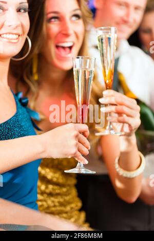 Junge Leute im Club oder bar Champagner trinken und Spaß haben Stockfoto