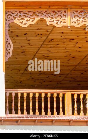 Veranda mit geschnitzter Holzdekor. Sonniger Herbsttag. Vorderansicht. Krim, Sudak - 10. Oktober 2020. Stockfoto