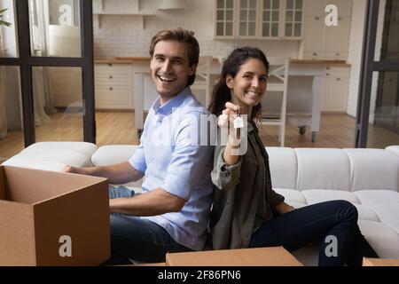 Portrait glückliche Familie begeistert von Umzug, neue Wohnung, zeigt Schlüssel Stockfoto
