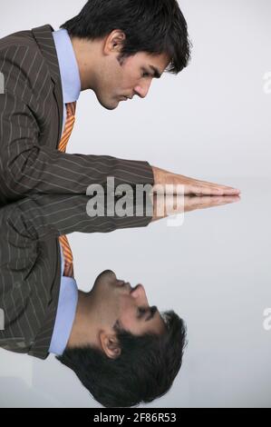 Spiegelung des Geschäftsmannes im Konferenzzimmertisch Stockfoto