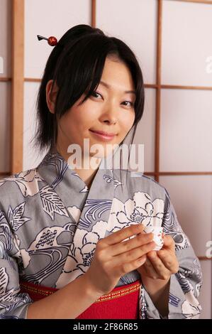 Portrait schöne junge Frau in japanischem Kimono mit Tee Stockfoto