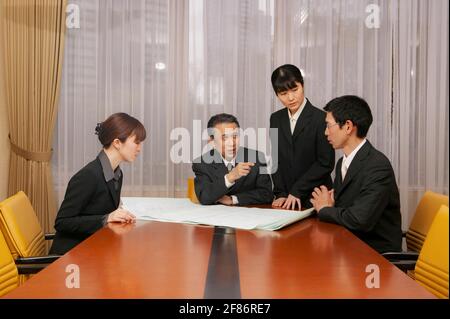 Geschäftsleute diskutieren im Büro-Konferenzraum über Entwürfe Stockfoto