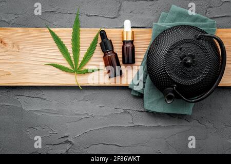 Vintage Teekanne mit Cannabis Kräutertee und frische Marihuana Blätter auf Beton Hintergrund gesetzt. Stockfoto