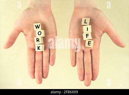 Arbeit und Leben. Weibliche Hände mit Würfeln auf hellem Hintergrund. Konzept der Balance, Harmonie, kein Stress, Ungleichgewicht. Auswahl Stockfoto