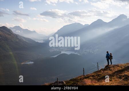 Orangefarbener Sonnenuntergang über der malerischen Stadt Sankt Moritz vom Gipfel des Muottas Muragl während eines lauwarmen Sommertages (St.. Moritz, Schweiz) Stockfoto