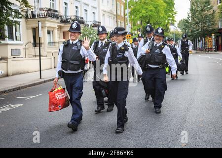 Britische Metropolitan Police Officers in hohen viz Jacken, lächelnd, als sie zu Notthing Hill Carnival, London, Großbritannien, gehen Stockfoto