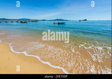 Türkisfarbenes Wasser und sanfte Wellen am Strand von Dunk Island, Queensland, QLD, Australien Stockfoto