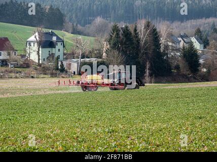 Traktor sprüht Pestizide auf ein Feld Stockfoto