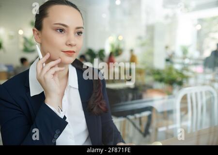 Porträt einer schönen nachdenklichen jungen Geschäftsfrau, die am Kaffeetisch sitzt Und über Ideen für neue Geschäfte nachzudenken Stockfoto