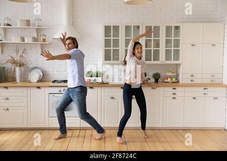 Überglücklich junges Paar, das in der Küche tanzt und Spaß zusammen hat Stockfoto