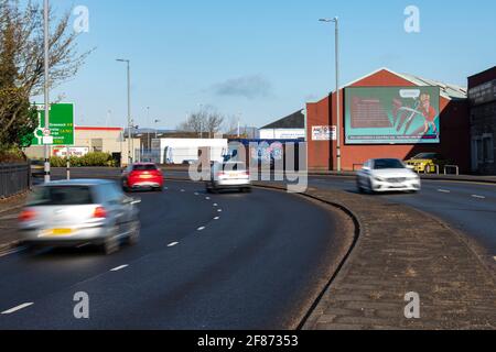 Greenock, Inverclyde, Schottland, Großbritannien. April 2021. IM BILD: Auf einer riesigen elektronischen Plakatwand zeigt Nicola Sturgeon, wie sie eine riesige Schere in einer Nachstellung der Dienstkürzungen ihrer Regierung im Royal Hospital von Inverclyde führt, nachdem sie versprochen hatte, sie zu behalten. Scotland Matters Pressemitteilung Link: https://www.scotlandmatters.co.uk/inverclyde-hospital-cuts-billboard-by-scotland-matters/ Bild: Colin Fisher/Alamy Live News Stockfoto