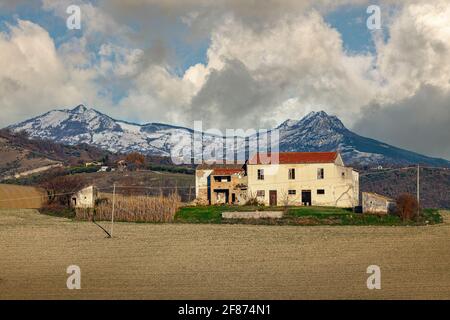 Verlassene Bauernhaus in den Hügeln der Abruzzen. Im Hintergrund die Gran Sasso Kette. Abruzzen, Italien, Europa Stockfoto