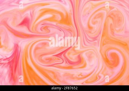 Abstrakte Hintergrundtextur aus wirbelnden oder fließenden Orange und Pink Tinte oder Pigment bilden eine künstlerische Mischung von Farben für Eine Designvorlage Stockfoto