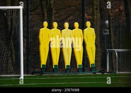 Gelbe Kunststoff-Freistoß-Dummies auf dem Rand des Feld neben einem Ziel Stockfoto