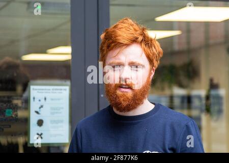 Halesowen, West Midlands, Großbritannien. April 2021. Firmenchef Rhys Barrett, 27, geht zu seinem Barbier in Halesowen, West Midlands, um einen willkommenen Haarschnitt und Bartschnitt zu erhalten, während sich die Barbiere nach der Lockerung der Covid-Beschränkungen heute öffnen. Kredit: Peter Lopeman/Alamy Live Nachrichten Stockfoto