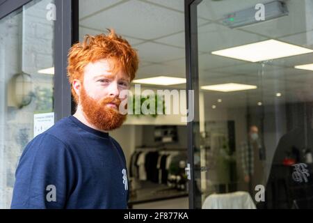 Halesowen, West Midlands, Großbritannien. April 2021. Firmenchef Rhys Barrett, 27, geht zu seinem Barbier in Halesowen, West Midlands, um einen willkommenen Haarschnitt und Bartschnitt zu erhalten, während sich die Barbiere nach der Lockerung der Covid-Beschränkungen heute öffnen. Kredit: Peter Lopeman/Alamy Live Nachrichten Stockfoto