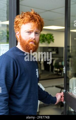 Halesowen, West Midlands, Großbritannien. April 2021. Firmenchef Rhys Barrett, 27, geht zu seinem Barbier in Halesowen, West Midlands, um einen willkommenen Haarschnitt und Bartschnitt zu erhalten, während sich die Barbiere nach der Lockerung der Covid-Beschränkungen heute öffnen. Kredit: Peter Lopeman/Alamy Live Nachrichten Stockfoto