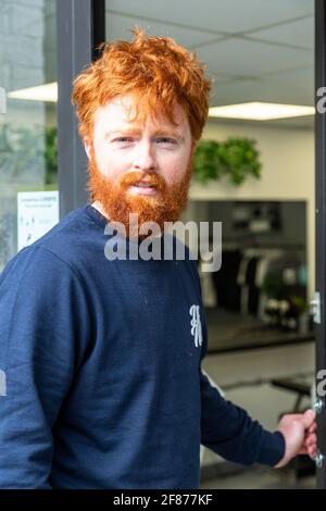 Halesowen, West Midlands, Großbritannien. April 2021. Firmenchef Rhys Barrett, 27, geht zu seinem Barbier in Halesowen, West Midlands, um einen willkommenen Haarschnitt und Bartschnitt zu erhalten, während sich die Barbiere nach der Lockerung der Covid-Beschränkungen heute öffnen. Kredit: Peter Lopeman/Alamy Live Nachrichten Stockfoto