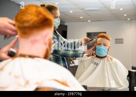 Halesowen, West Midlands, Großbritannien. April 2021. Firmenchef Rhys Barrett, 27, lässt sich von Sam Whitlock, Miteigentümer von Label Male Image in Halesowen, West Midlands, die Haare schneiden, da sich heute nach der Lockerung der Covid-Beschränkungen die Barber öffnen. Kredit: Peter Lopeman/Alamy Live Nachrichten Stockfoto