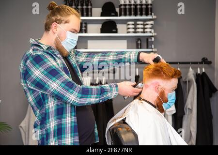 Halesowen, West Midlands, Großbritannien. April 2021. Firmenchef Rhys Barrett, 27, lässt sich von Sam Whitlock, Miteigentümer von Label Male Image in Halesowen, West Midlands, die Haare schneiden, da sich heute nach der Lockerung der Covid-Beschränkungen die Barber öffnen. Kredit: Peter Lopeman/Alamy Live Nachrichten Stockfoto