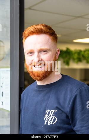 Halesowen, West Midlands, Großbritannien. April 2021. Firmenchef Rhys Barrett, 27, verlässt bei Label Male Image Barbers in Halesowen, West Midlands, glücklich mit Haarschnitt und Bartschnitt, da sich die Barbiere nach der Lockerung der Covid-Beschränkungen heute öffnen. Kredit: Peter Lopeman/Alamy Live Nachrichten Stockfoto