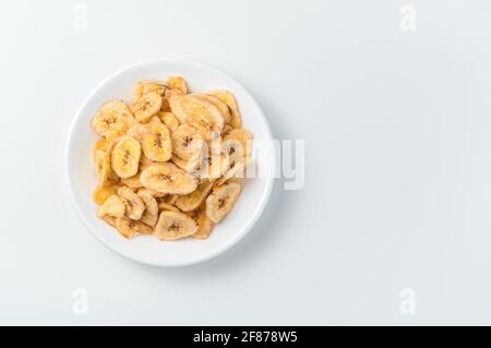 Getrocknete Bananenchips auf weißem Hintergrund. Draufsicht, Kopierbereich. Stockfoto