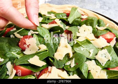 Pizza mit Käse, Tomaten, Spinat und Räucherwurst Stockfoto
